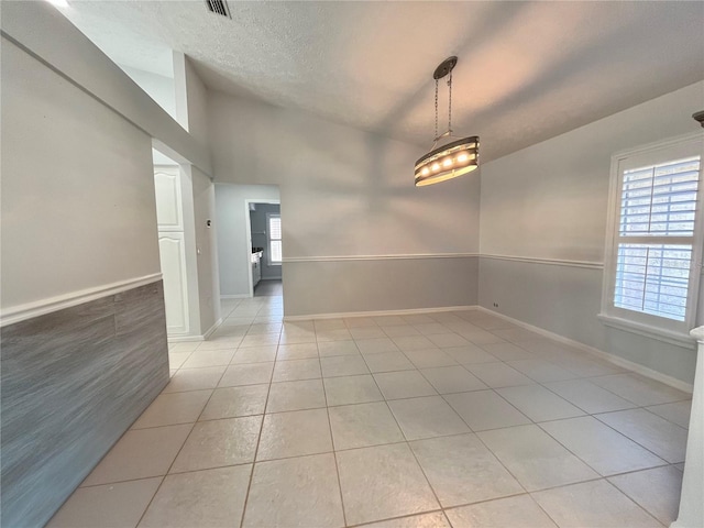 10060 Chip Ln, New Port Richey, FL 34654 - spare room with light tile patterned floors, a textured ceiling, and vaulted ceiling