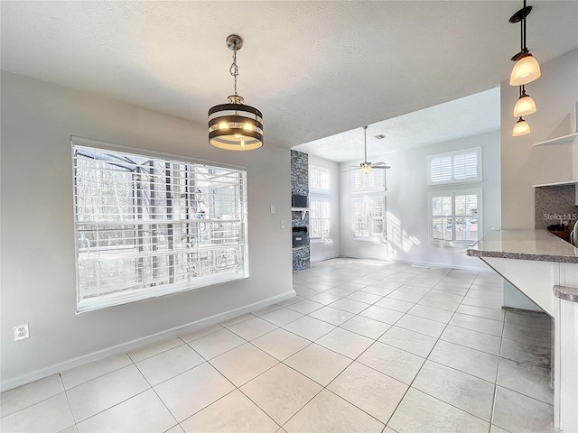 10060 Chip Ln, New Port Richey, FL 34654 - unfurnished dining area with light tile patterned floors, a textured ceiling, and ceiling fan