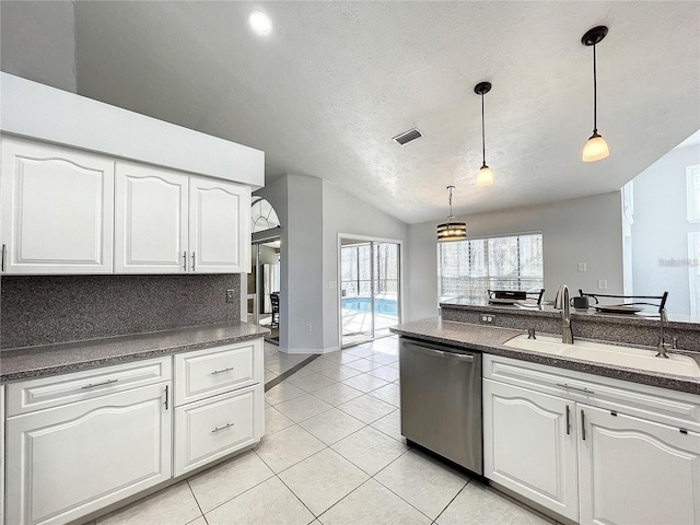 10060 Chip Ln, New Port Richey, FL 34654 - kitchen with stainless steel dishwasher, dark countertops, lofted ceiling, a textured ceiling, and light tile patterned flooring