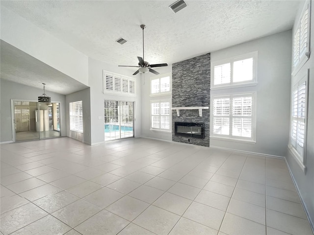 10060 Chip Ln, New Port Richey, FL 34654 - unfurnished living room featuring a textured ceiling, a ceiling fan, healthy amount of natural light, light tile patterned floors, and a high ceiling