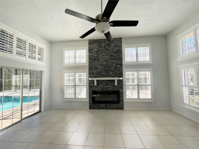 10060 Chip Ln, New Port Richey, FL 34654 - unfurnished living room with a textured ceiling, ceiling fan, a fireplace, tile patterned flooring, and a towering ceiling