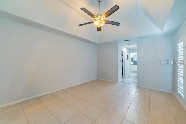 10060 Chip Ln, New Port Richey, FL 34654 - empty room featuring a tray ceiling, light tile patterned floors, and healthy amount of natural light