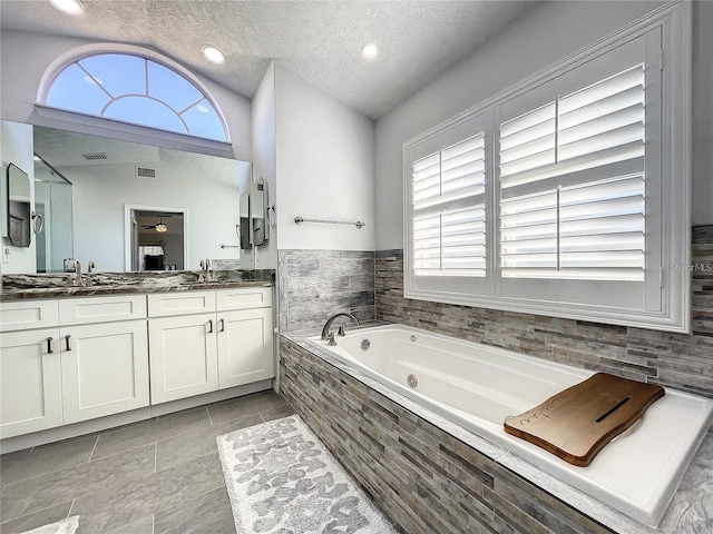 10060 Chip Ln, New Port Richey, FL 34654 - full bath featuring double vanity, a whirlpool tub, healthy amount of natural light, and a textured ceiling