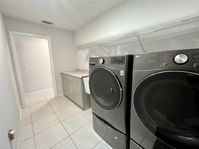 10060 Chip Ln, New Port Richey, FL 34654 - washroom with separate washer and dryer, cabinet space, and light tile patterned flooring