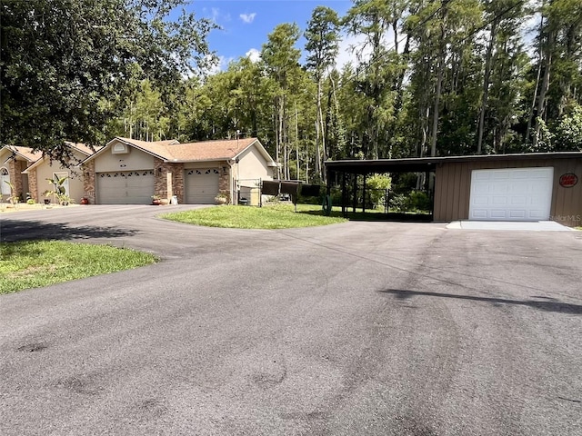 10060 Chip Ln, New Port Richey, FL 34654 - view of front of property featuring a carport, board and batten siding, driveway, and a garage