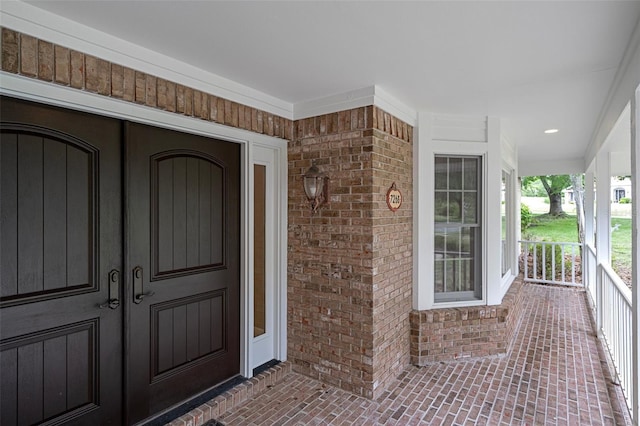 7268 Crystal Spring Run, Weeki Wachee, FL 34607 - view of exterior entry featuring covered porch, brick siding, and french doors