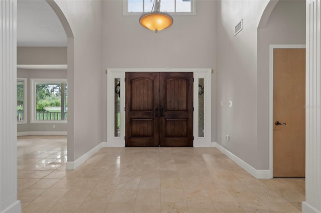 7268 Crystal Spring Run, Weeki Wachee, FL 34607 - entryway with a towering ceiling, arched walkways, plenty of natural light, and light tile patterned floors