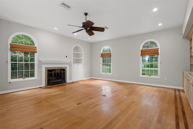 7268 Crystal Spring Run, Weeki Wachee, FL 34607 - unfurnished living room featuring a fireplace, healthy amount of natural light, light wood-style floors, built in features, and recessed lighting