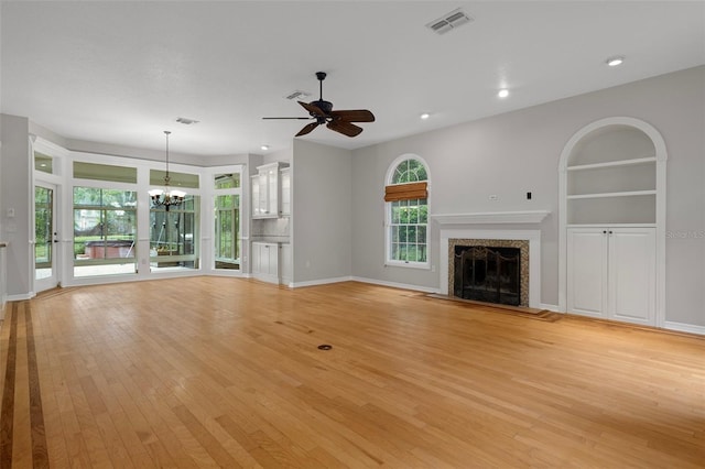7268 Crystal Spring Run, Weeki Wachee, FL 34607 - unfurnished living room featuring a chandelier, light wood-style floors, a fireplace, a ceiling fan, and recessed lighting