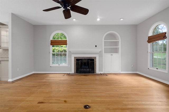 7268 Crystal Spring Run, Weeki Wachee, FL 34607 - unfurnished living room with plenty of natural light, light wood finished floors, a fireplace with flush hearth, radiator heating unit, and recessed lighting