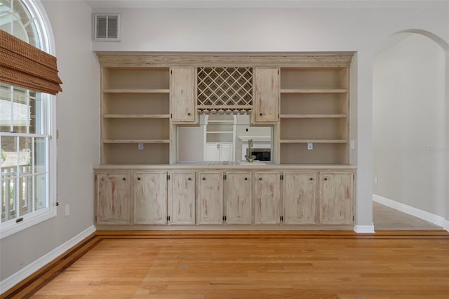 7268 Crystal Spring Run, Weeki Wachee, FL 34607 - unfurnished dining area with arched walkways, light wood-type flooring, and bar