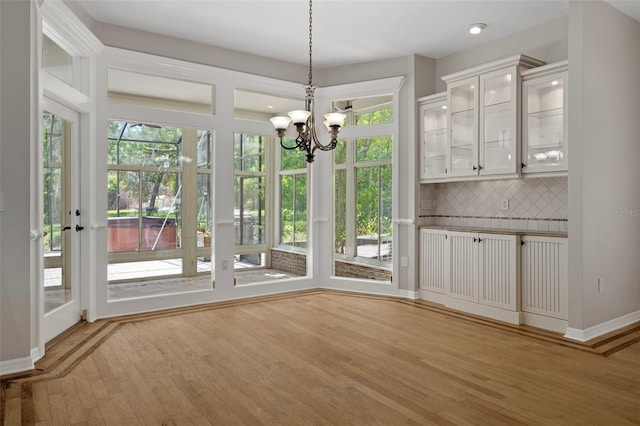 7268 Crystal Spring Run, Weeki Wachee, FL 34607 - unfurnished dining area with plenty of natural light, wood finished floors, and a chandelier