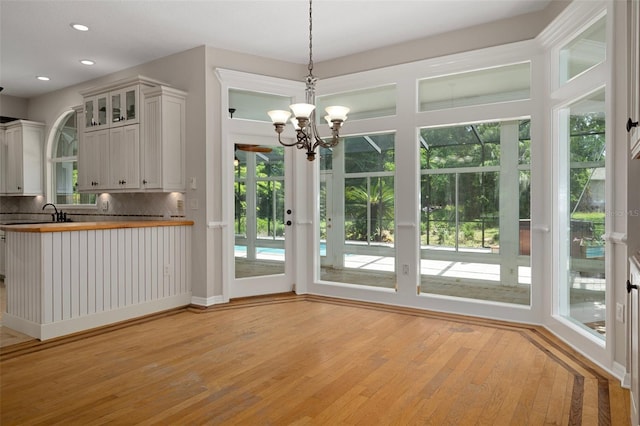 7268 Crystal Spring Run, Weeki Wachee, FL 34607 - kitchen with backsplash, light wood finished floors, a chandelier, healthy amount of natural light, and recessed lighting