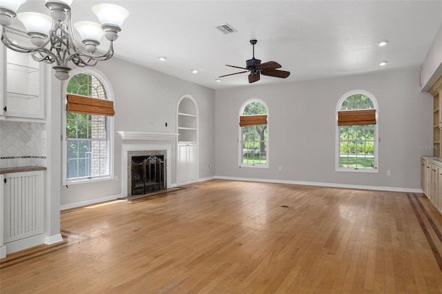 7268 Crystal Spring Run, Weeki Wachee, FL 34607 - unfurnished living room featuring ceiling fan, a chandelier, a fireplace, light wood-style flooring, and recessed lighting