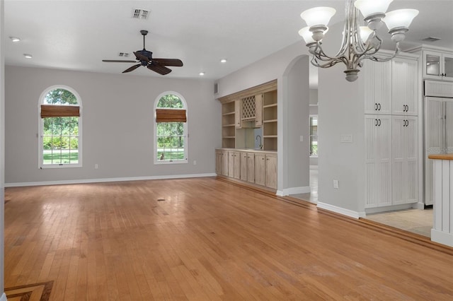 7268 Crystal Spring Run, Weeki Wachee, FL 34607 - unfurnished living room featuring ceiling fan, light wood-style floors, a chandelier, arched walkways, and recessed lighting