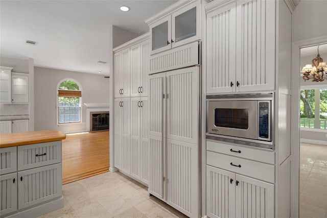 7268 Crystal Spring Run, Weeki Wachee, FL 34607 - kitchen with built in appliances, healthy amount of natural light, a chandelier, glass insert cabinets, and recessed lighting