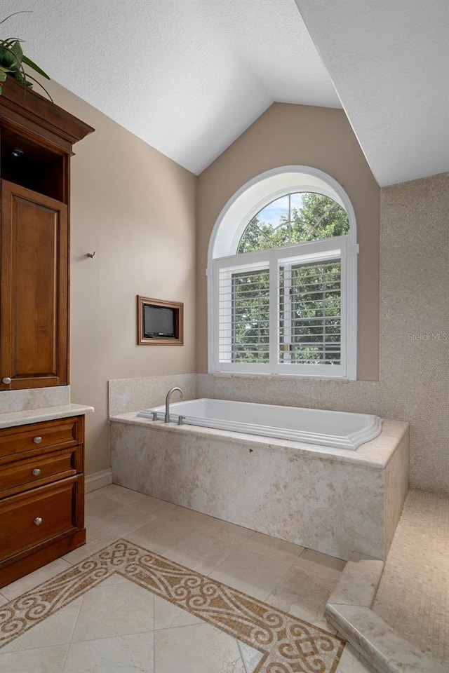 7268 Crystal Spring Run, Weeki Wachee, FL 34607 - full bathroom with vaulted ceiling, a garden tub, vanity, and tile patterned flooring