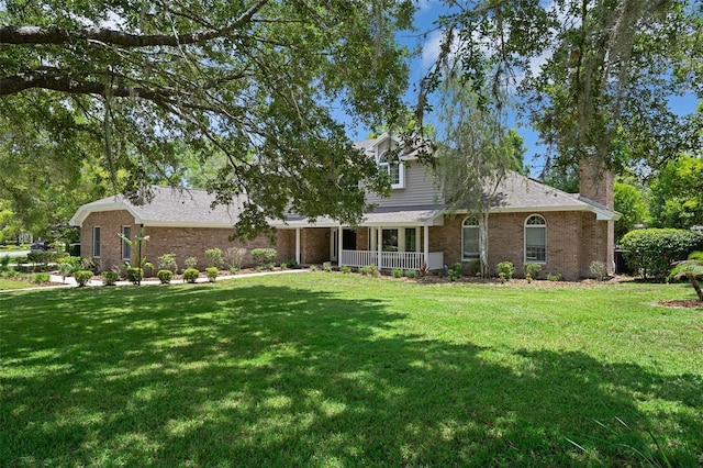 7268 Crystal Spring Run, Weeki Wachee, FL 34607 - view of front facade with brick siding, a porch, a front yard, and a chimney