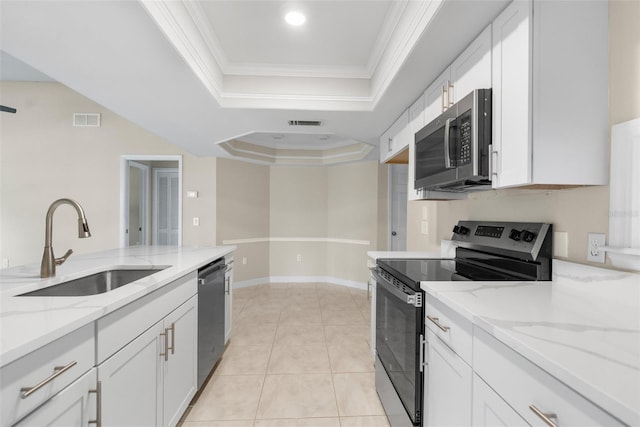 6509 Pine Meadows Dr, Spring Hill, FL 34606 - kitchen with stainless steel appliances, a tray ceiling, ornamental molding, white cabinetry, and light stone countertops