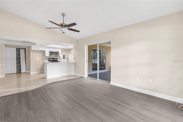 6509 Pine Meadows Dr, Spring Hill, FL 34606 - unfurnished living room featuring a ceiling fan, vaulted ceiling, and light wood-type flooring