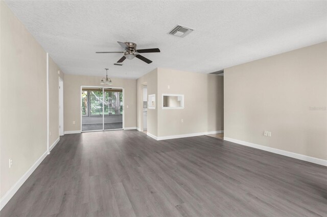 6509 Pine Meadows Dr, Spring Hill, FL 34606 - unfurnished living room with ceiling fan, dark wood-style floors, a textured ceiling, and a chandelier