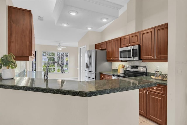 11418 Tee Time Cir, New Port Richey, FL 34654 - kitchen featuring stainless steel appliances, tasteful backsplash, a peninsula, a ceiling fan, and light tile patterned floors