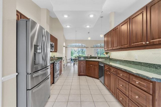 11418 Tee Time Cir, New Port Richey, FL 34654 - kitchen with stainless steel appliances, a peninsula, light tile patterned floors, backsplash, and dark stone countertops