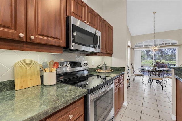 11418 Tee Time Cir, New Port Richey, FL 34654 - kitchen featuring appliances with stainless steel finishes, a chandelier, tasteful backsplash, light tile patterned floors, and lofted ceiling