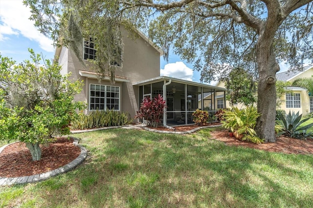 11418 Tee Time Cir, New Port Richey, FL 34654 - back of property featuring a sunroom, a lawn, and stucco siding