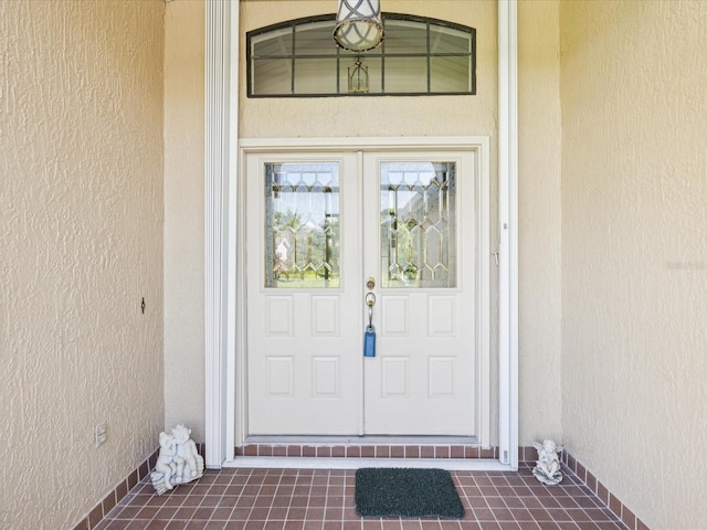 8401 Pavilion Dr, Hudson, FL 34667 - doorway to property featuring stucco siding and french doors