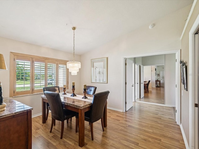 8401 Pavilion Dr, Hudson, FL 34667 - dining area featuring vaulted ceiling, light wood-type flooring, and a chandelier