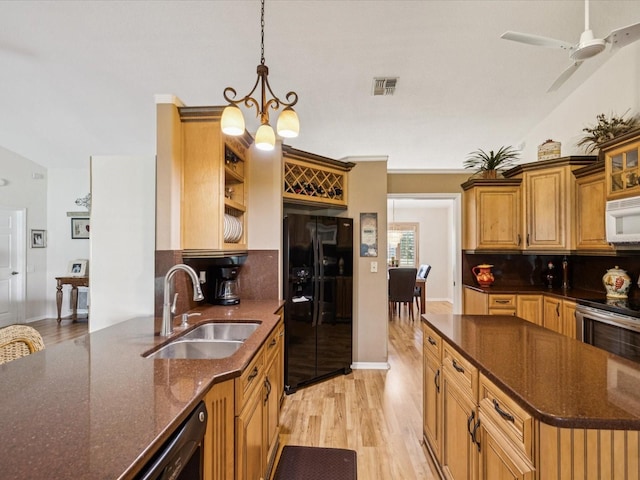 8401 Pavilion Dr, Hudson, FL 34667 - kitchen featuring black fridge, light wood-type flooring, tasteful backsplash, white microwave, and dark stone countertops