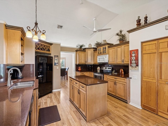 8401 Pavilion Dr, Hudson, FL 34667 - kitchen featuring white microwave, stainless steel electric range, black fridge, tasteful backsplash, and light wood-style floors