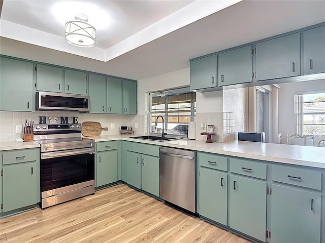 9425 Sterling Ln, Port Richey, FL 34668 - kitchen with appliances with stainless steel finishes, light countertops, tasteful backsplash, and light wood-style flooring