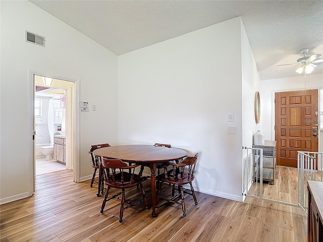9425 Sterling Ln, Port Richey, FL 34668 - dining area with light wood-style flooring, lofted ceiling, ceiling fan, and a textured ceiling