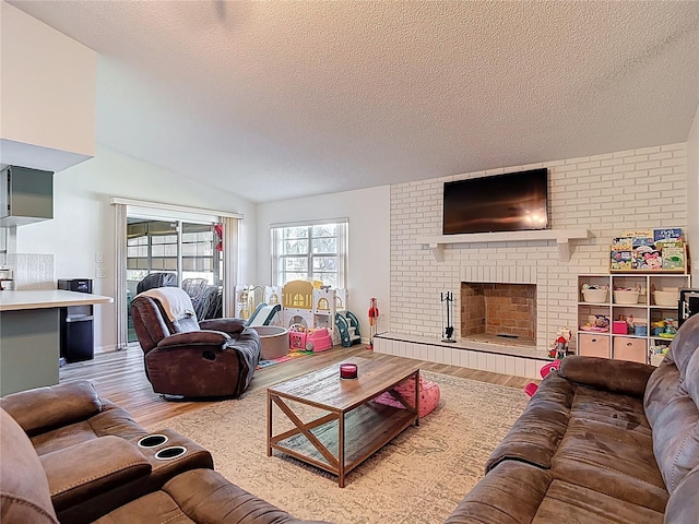 9425 Sterling Ln, Port Richey, FL 34668 - living room featuring wood finished floors, a brick fireplace, a textured ceiling, and vaulted ceiling