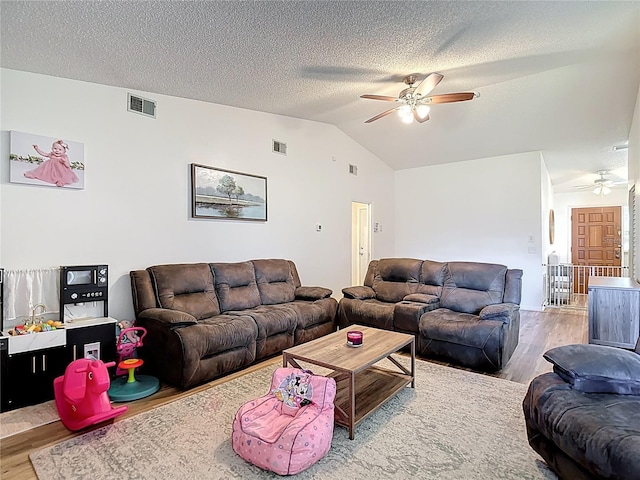 9425 Sterling Ln, Port Richey, FL 34668 - living area with a ceiling fan, wood finished floors, lofted ceiling, and a textured ceiling