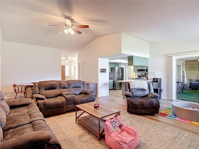 9425 Sterling Ln, Port Richey, FL 34668 - living area with ceiling fan, light wood-style floors, vaulted ceiling, and a textured ceiling