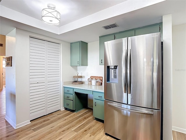 9425 Sterling Ln, Port Richey, FL 34668 - kitchen featuring stainless steel refrigerator with ice dispenser, green cabinets, light wood-style floors, and light countertops