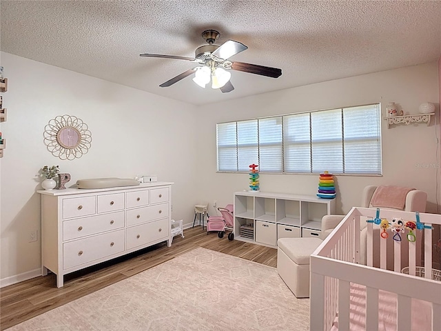 9425 Sterling Ln, Port Richey, FL 34668 - bedroom featuring wood finished floors, a crib, multiple windows, and a textured ceiling