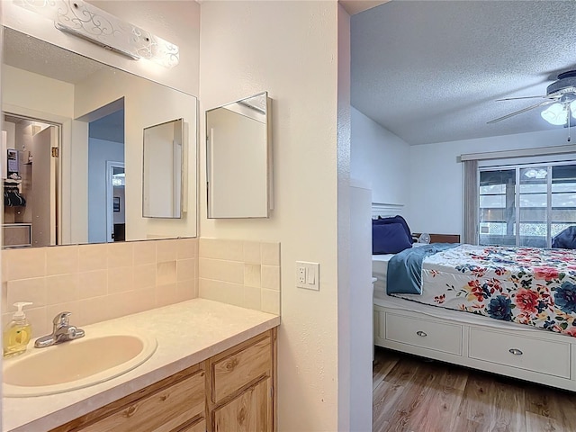 9425 Sterling Ln, Port Richey, FL 34668 - bathroom featuring ensuite bathroom, backsplash, wood finished floors, vanity, and ceiling fan
