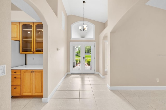 252 Arbor Woods Cir, Oldsmar, FL 34677 - foyer featuring arched walkways, french doors, light tile patterned floors, and high vaulted ceiling