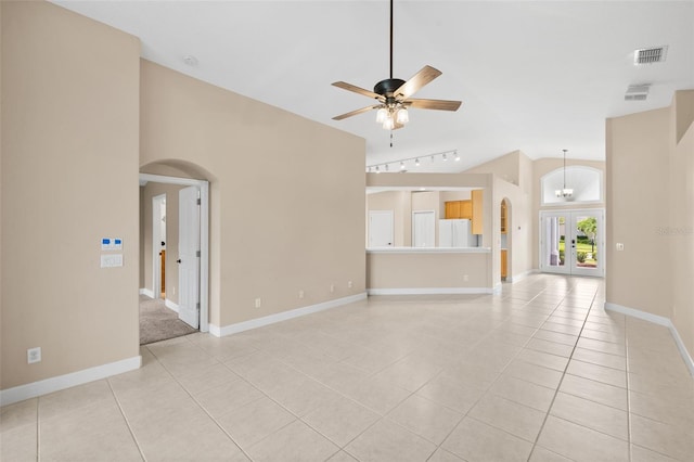 252 Arbor Woods Cir, Oldsmar, FL 34677 - unfurnished living room featuring arched walkways, light tile patterned floors, lofted ceiling, rail lighting, and a ceiling fan