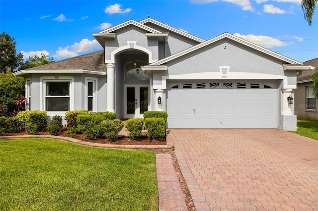 252 Arbor Woods Cir, Oldsmar, FL 34677 - view of front of property with french doors, stucco siding, a front yard, and an attached garage