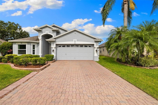 252 Arbor Woods Cir, Oldsmar, FL 34677 - ranch-style home featuring stucco siding, a front lawn, a garage, and decorative driveway