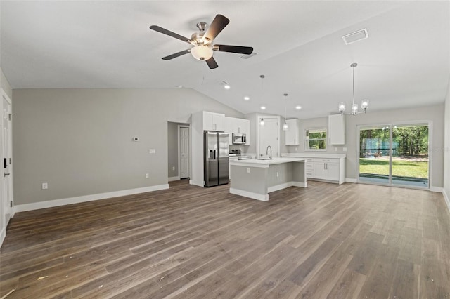 8782 N Sandree Dr, Citrus Springs, FL 34434 - unfurnished living room with vaulted ceiling, ceiling fan, wood finished floors, and a chandelier