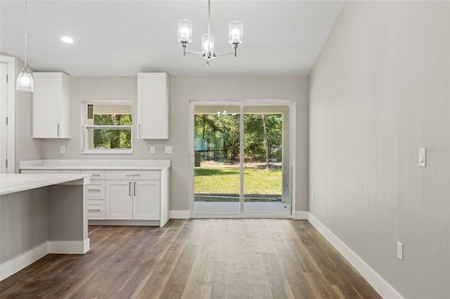 8782 N Sandree Dr, Citrus Springs, FL 34434 - unfurnished dining area featuring dark wood-style floors, plenty of natural light, and a chandelier