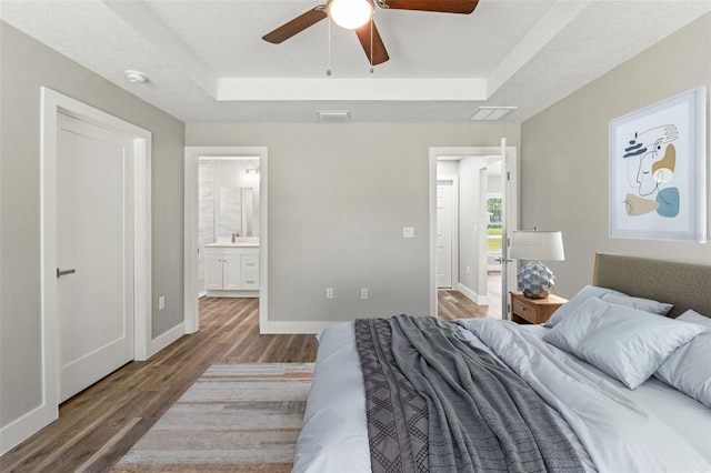 8782 N Sandree Dr, Citrus Springs, FL 34434 - bedroom with a raised ceiling, wood finished floors, connected bathroom, and a ceiling fan