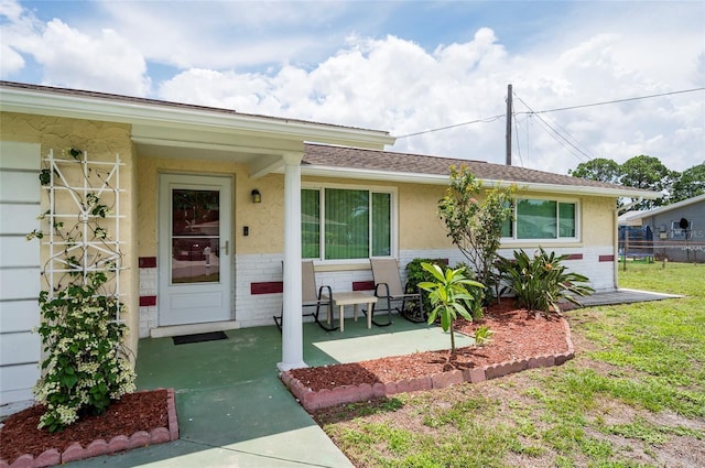 10600 Oleander Dr, Port Richey, FL 34668 - view of exterior entry with brick siding and stucco siding