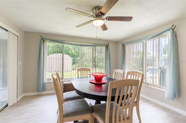 10600 Oleander Dr, Port Richey, FL 34668 - dining room featuring light wood-style floors, a ceiling fan, and a textured ceiling